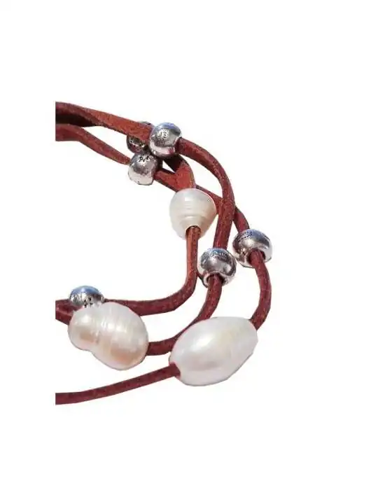 detalle de pulsera de tiras de cuero y perlas 