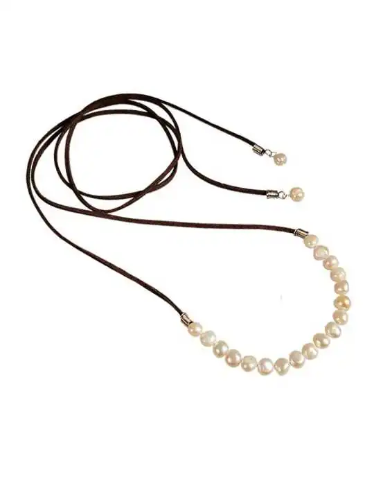 Detalle collar perlas y cuero