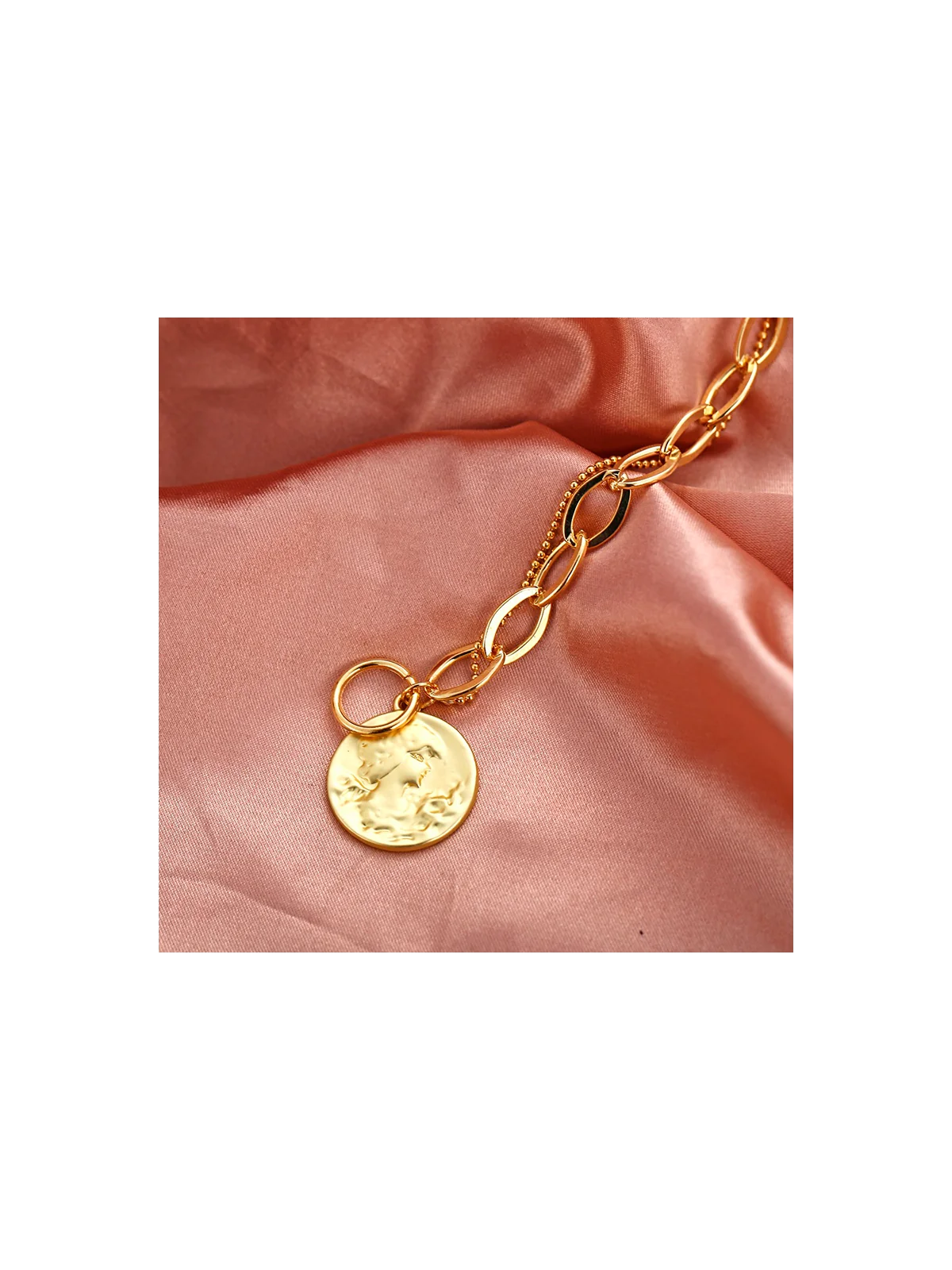 detalle de p ulsera con cadena dorada y moneda central 