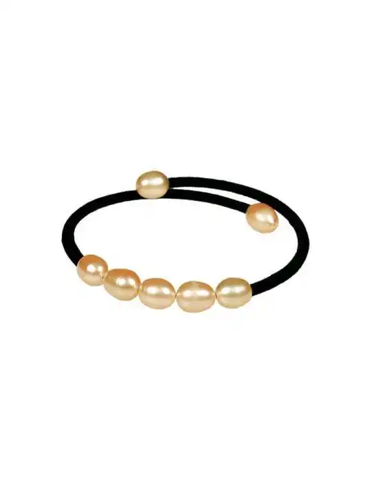 detalle de pulsera con perlas rosas y cinta de terciopelo