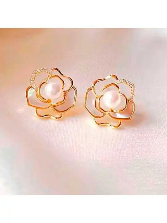 detalle de pendientes con filigrana dorada formando una camelia