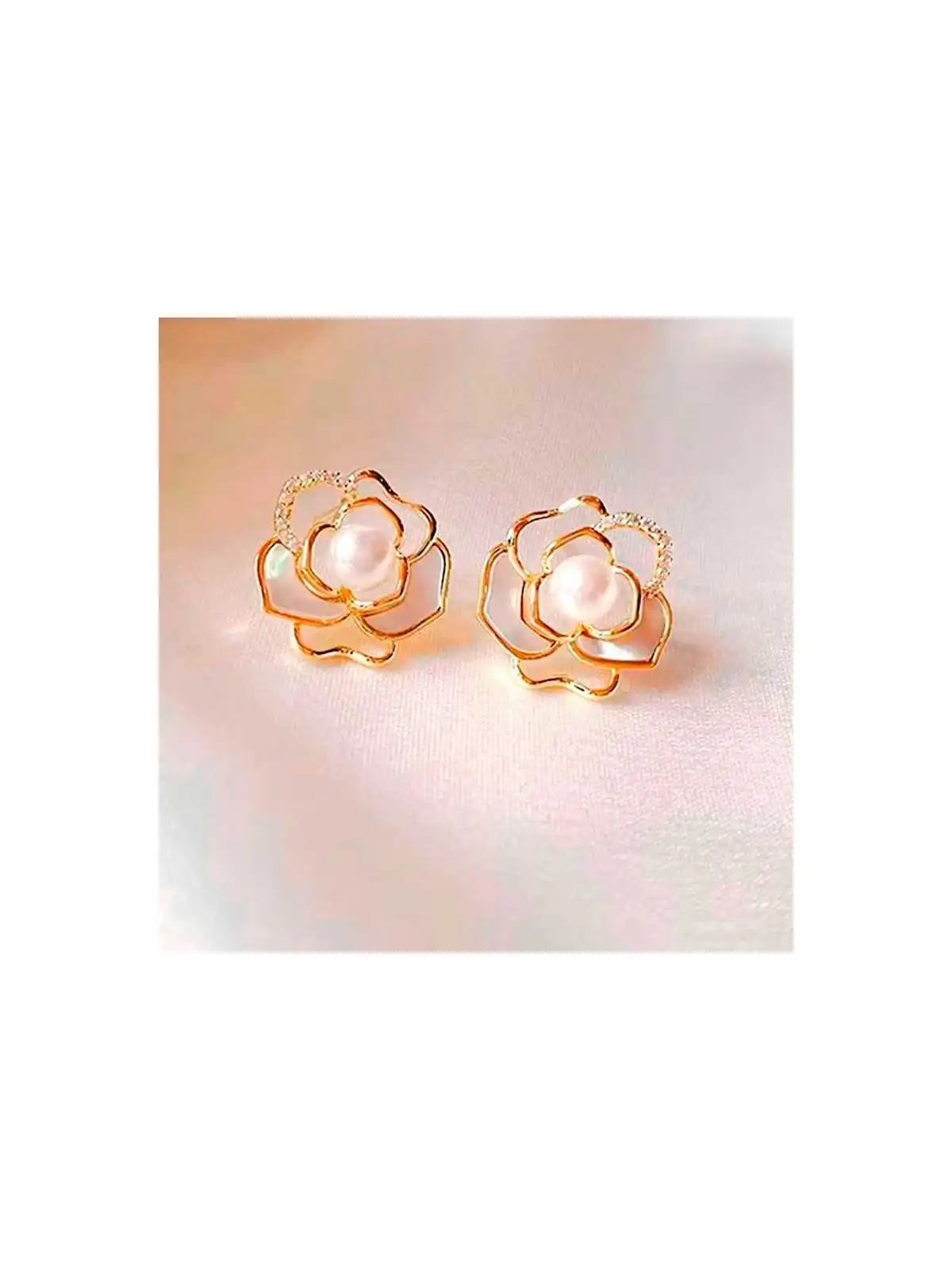 detalle de pendientes con filigrana dorada formando una camelia